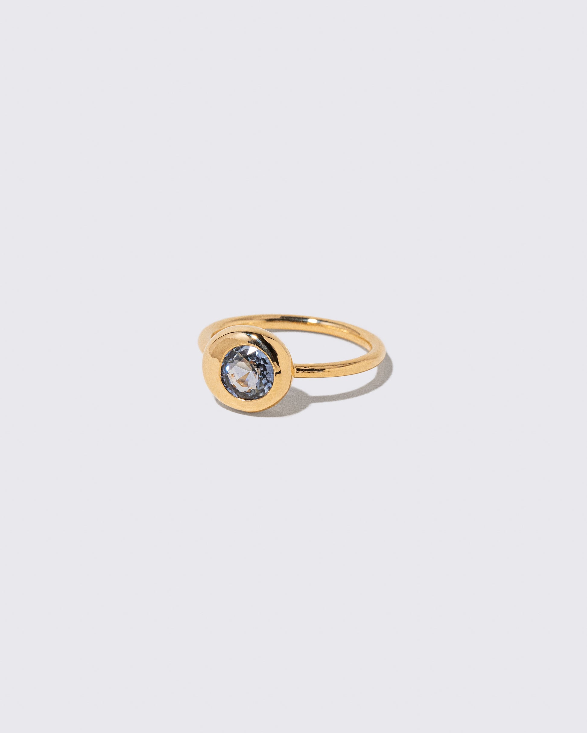 View from the side of the Bicolor Blue Sapphire Level Ring on light color background.