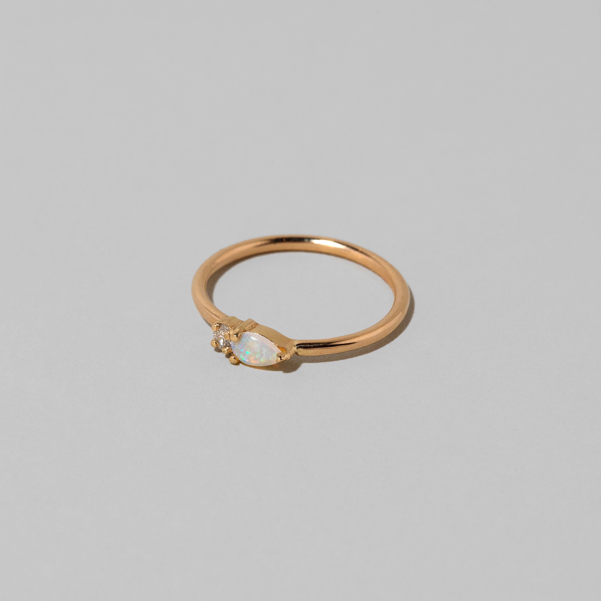 product_details::Closeup details of the Opal Teardrops Ring on light color background.