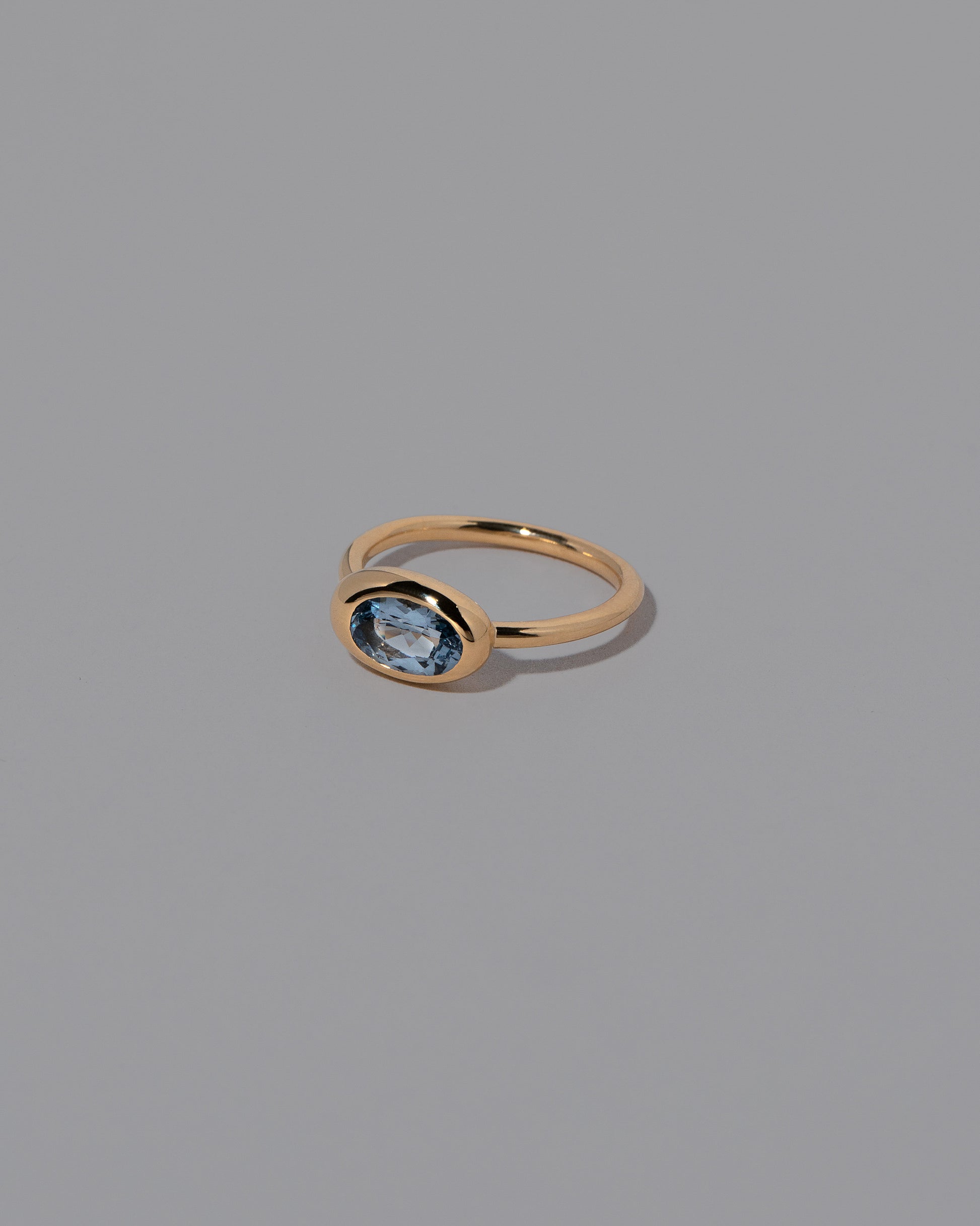 View from the side of the Oval Blue Sapphire Equalize Ring on light color background.