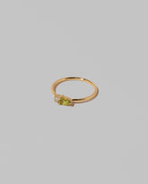 View from the side of the Peridot Teardrops Ring on light color background.