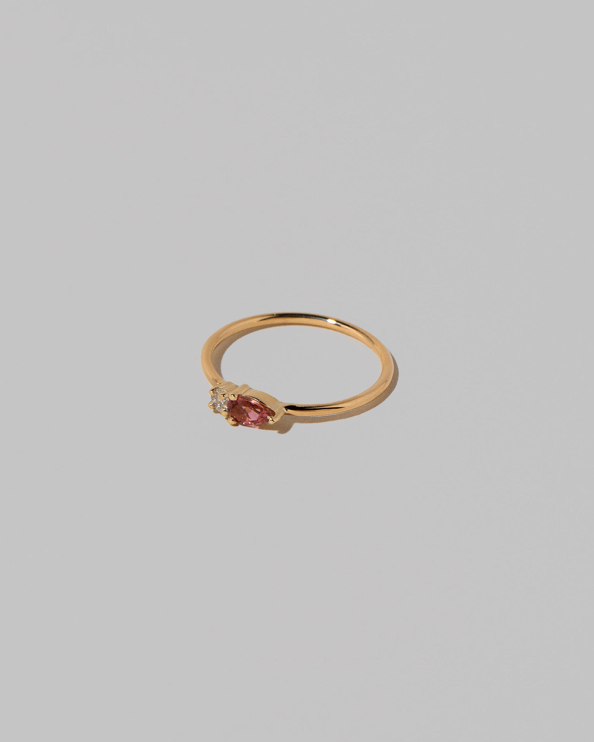 View from the side of the Pink Tourmaline Teardrops Ring on light color background.