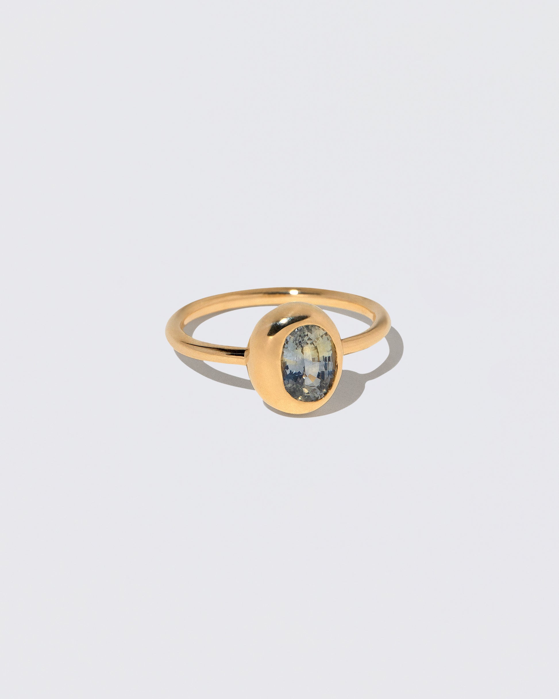 View from the side of the Oval Bicolor Sapphire Precise Ring on light color background.