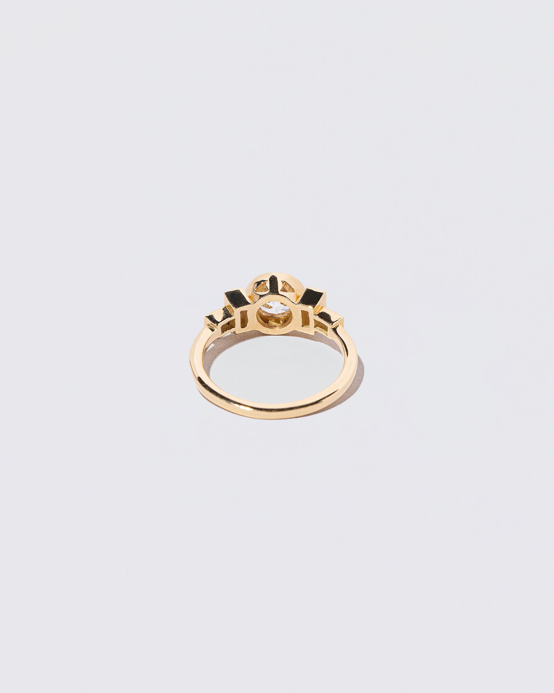 View from the back of the White Diamond & Blue Sapphire Third Eye Ring on light color background.