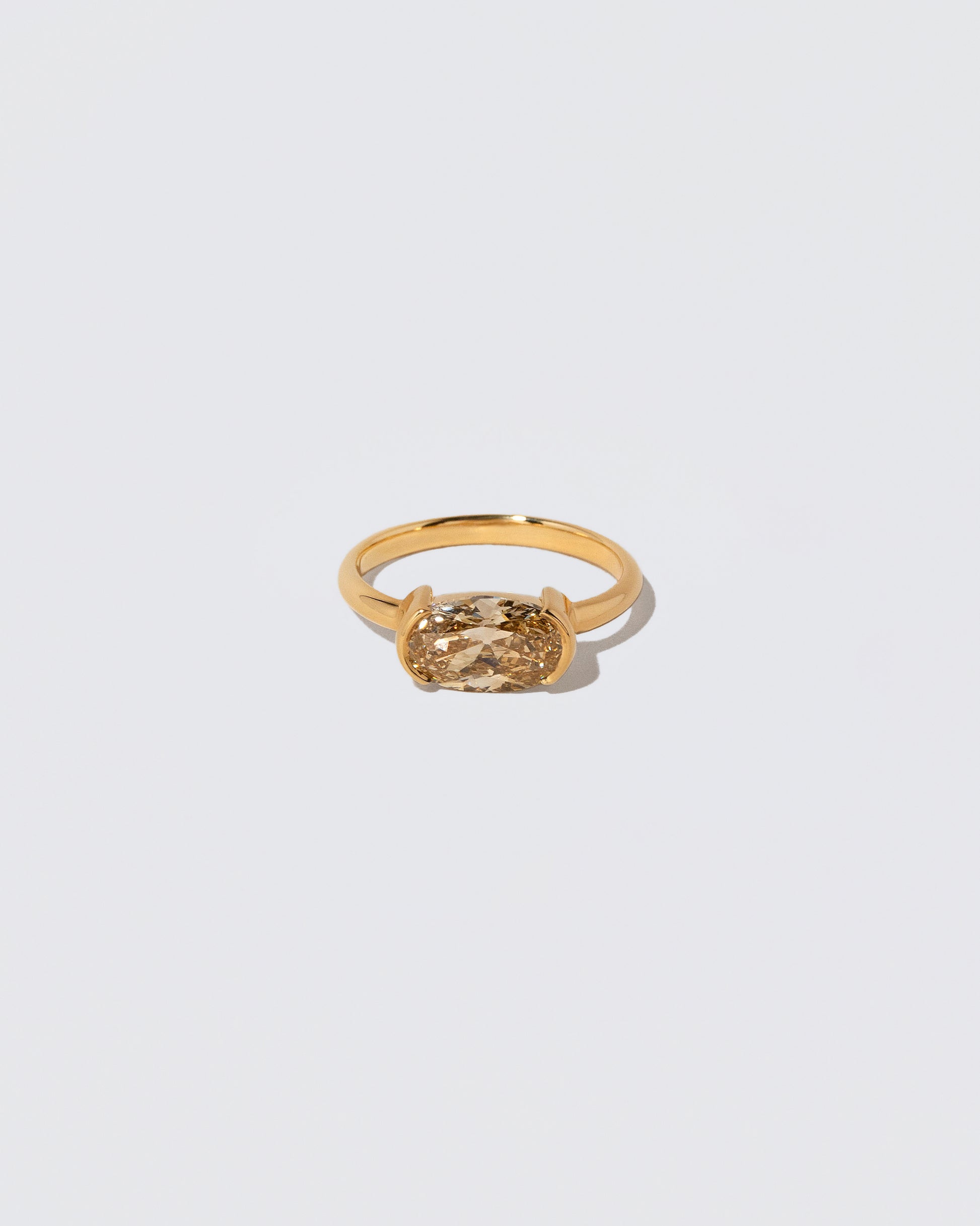 Oval Brown Diamond Transformation Ring on light color background.