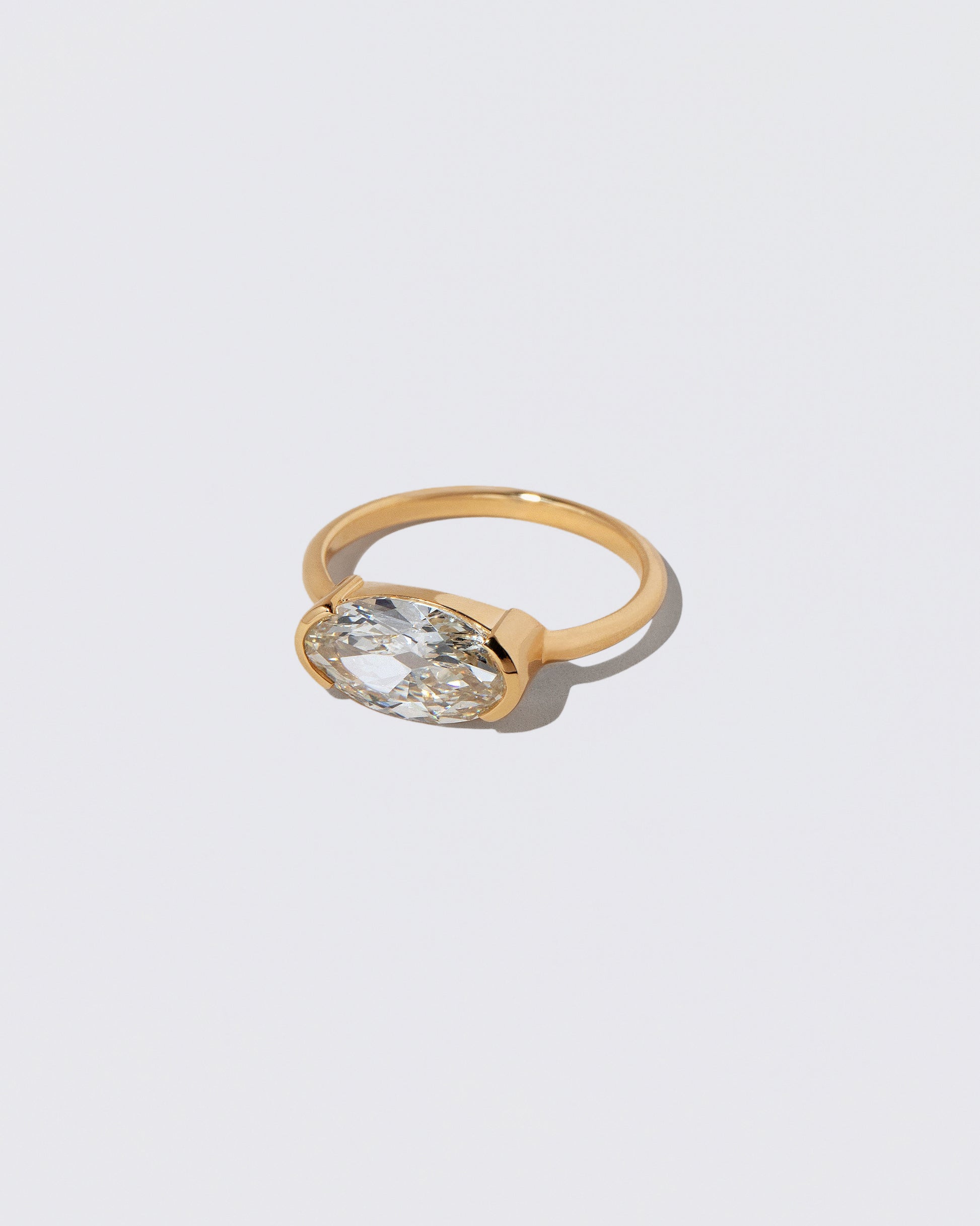View from the side of the Moval Diamond Transformation Ring on light color background.