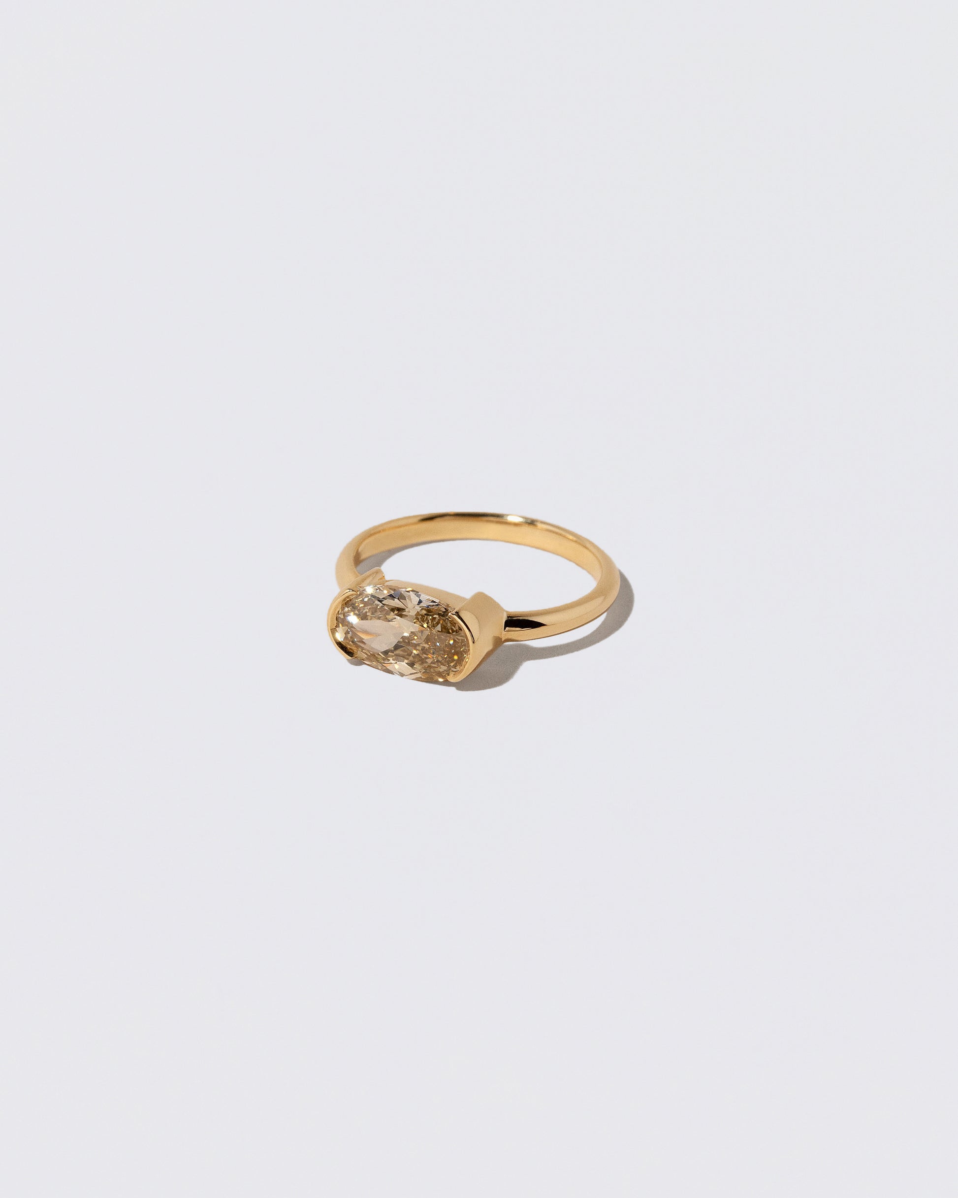 View from the side of the Oval Brown Diamond Transformation Ring on light color background.