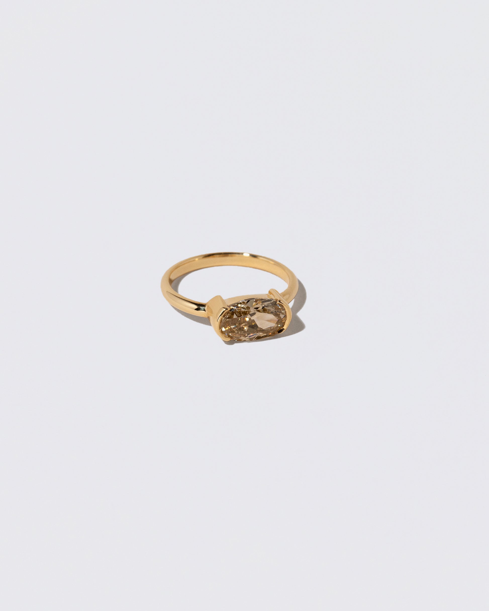 View from the side of the Oval Brown Diamond Transformation Ring on light color background.