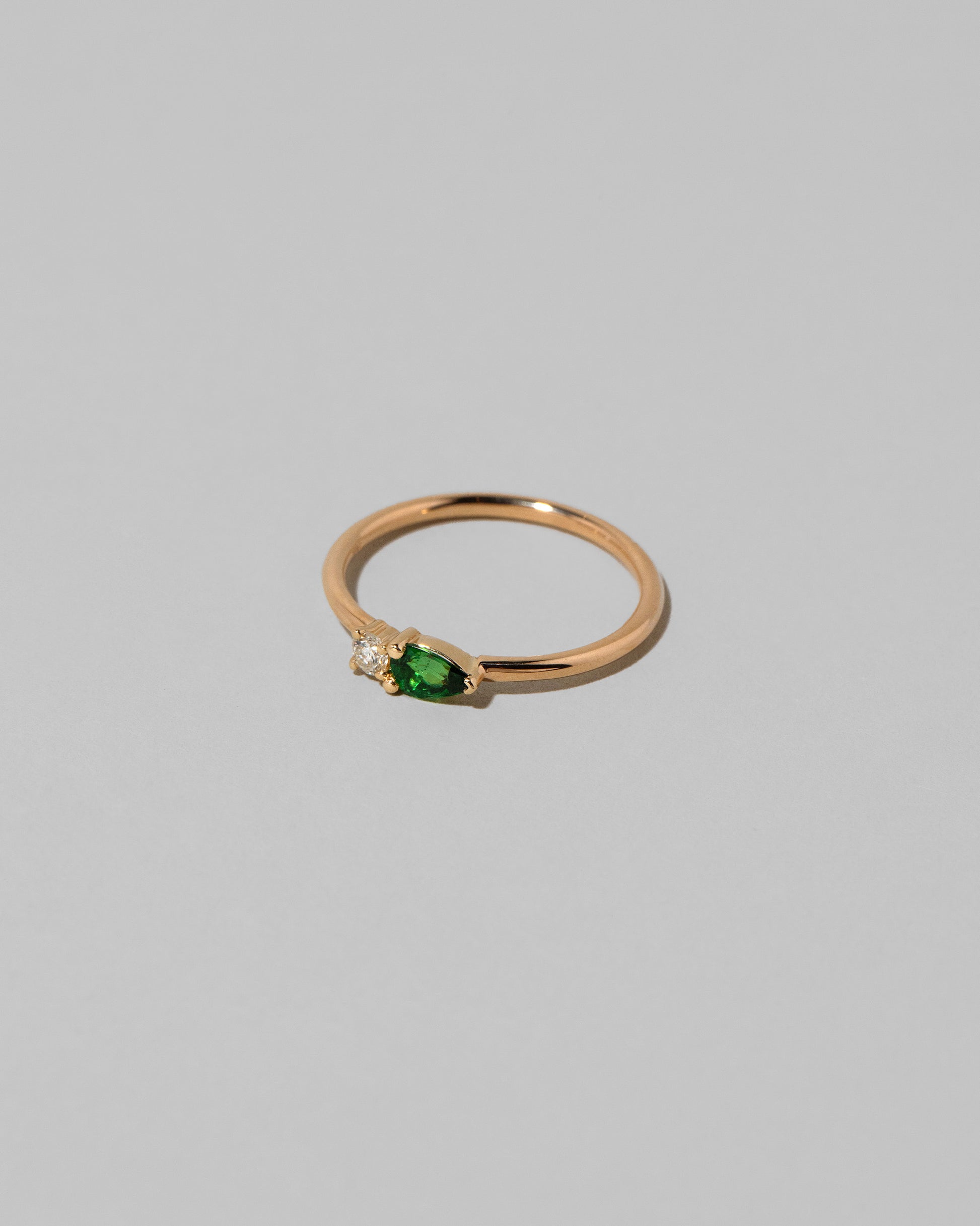 View from the side of the Tsavorite Teardrops Ring on light color background.