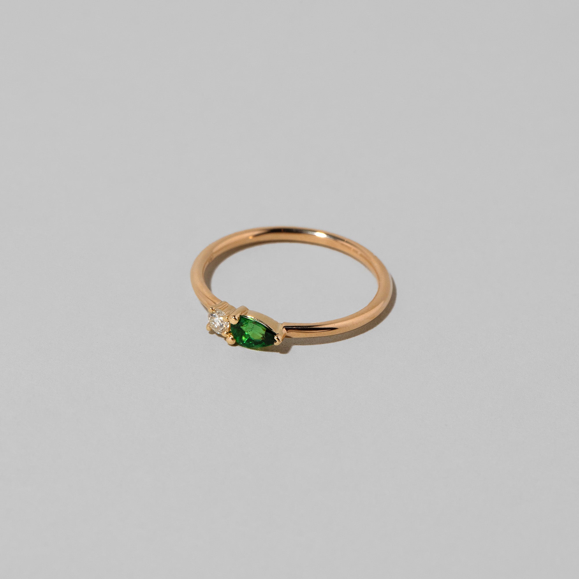 product_details::Closeup details of the Tsavorite Teardrops Ring on light color background.