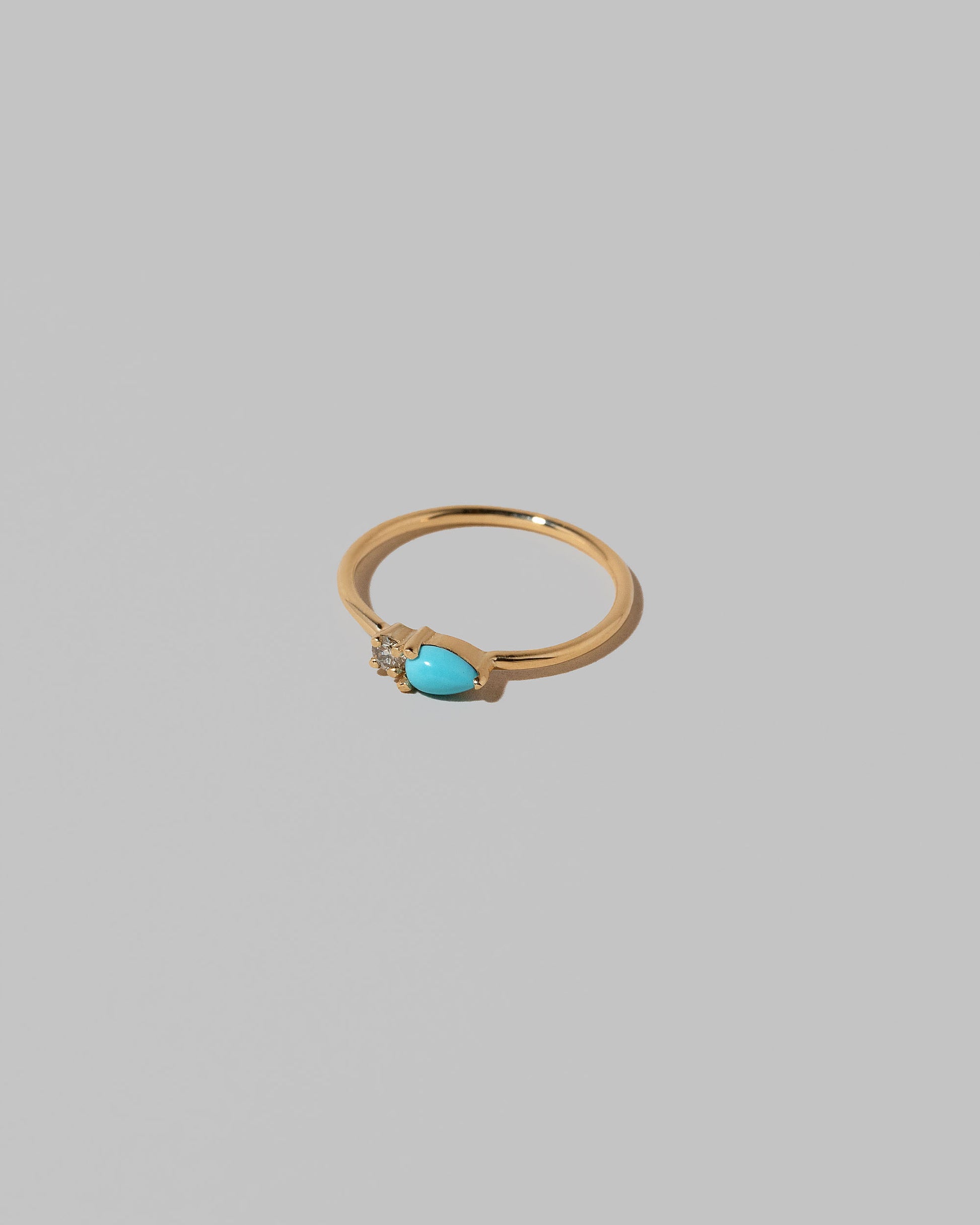 View from the side of the Turquoise Teardrops Ring on light color background.