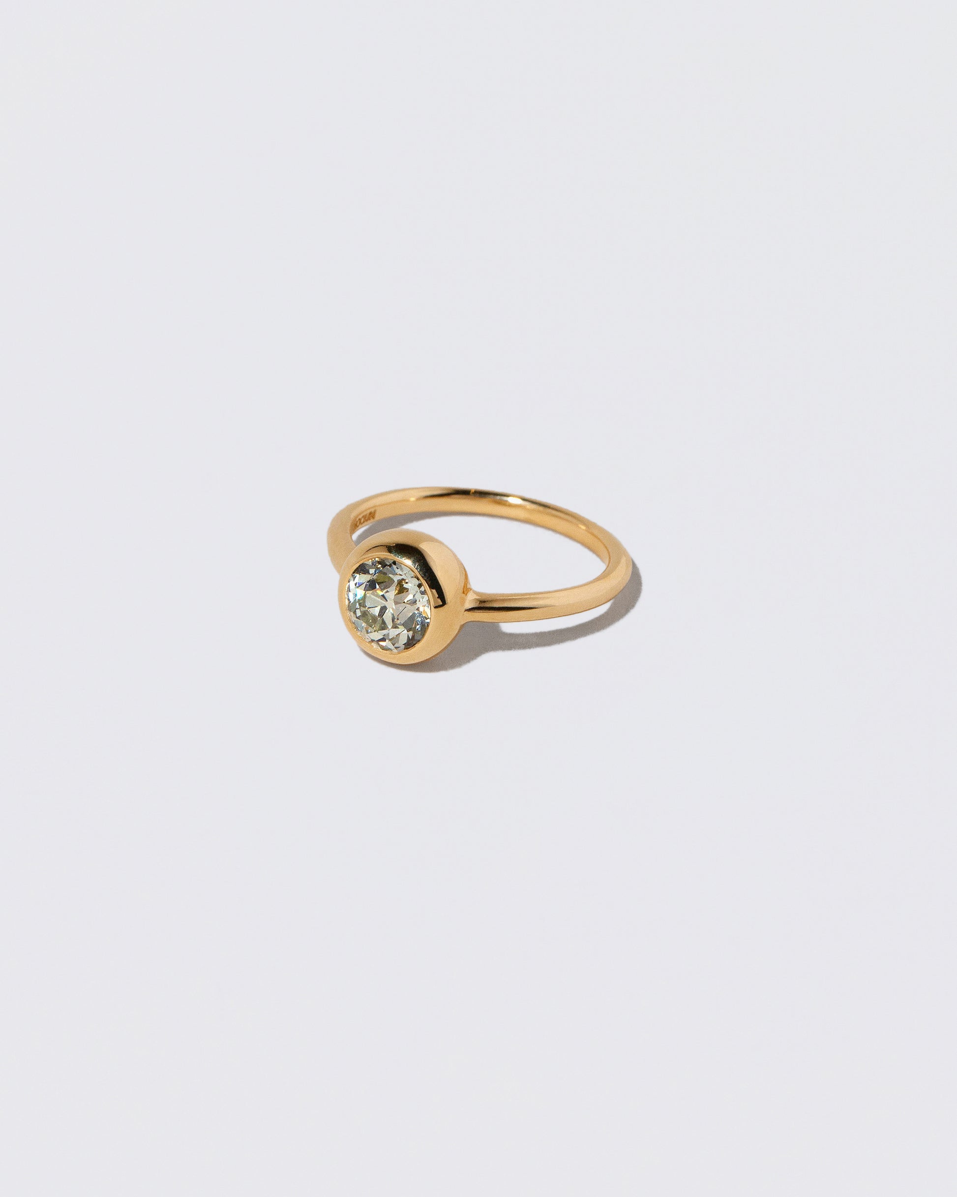 View from the side of a past version of the Diamond Wellspring Ring on light color background.