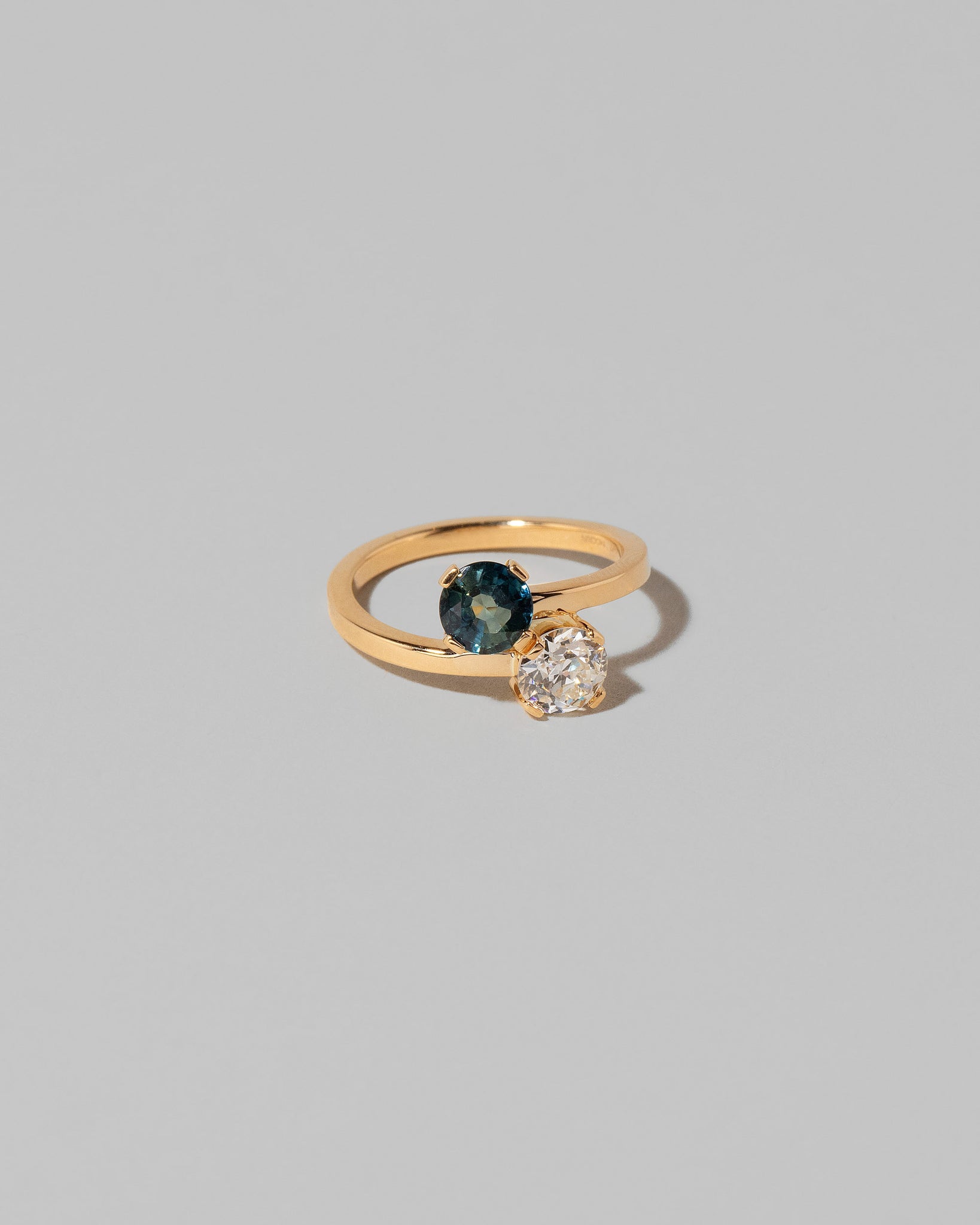 View from the side of the Sapphire & Diamond Union Ring on light color background.