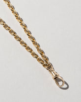 Closeup details of the Short Loop Chain Necklace and Swivel Fob on light color background.