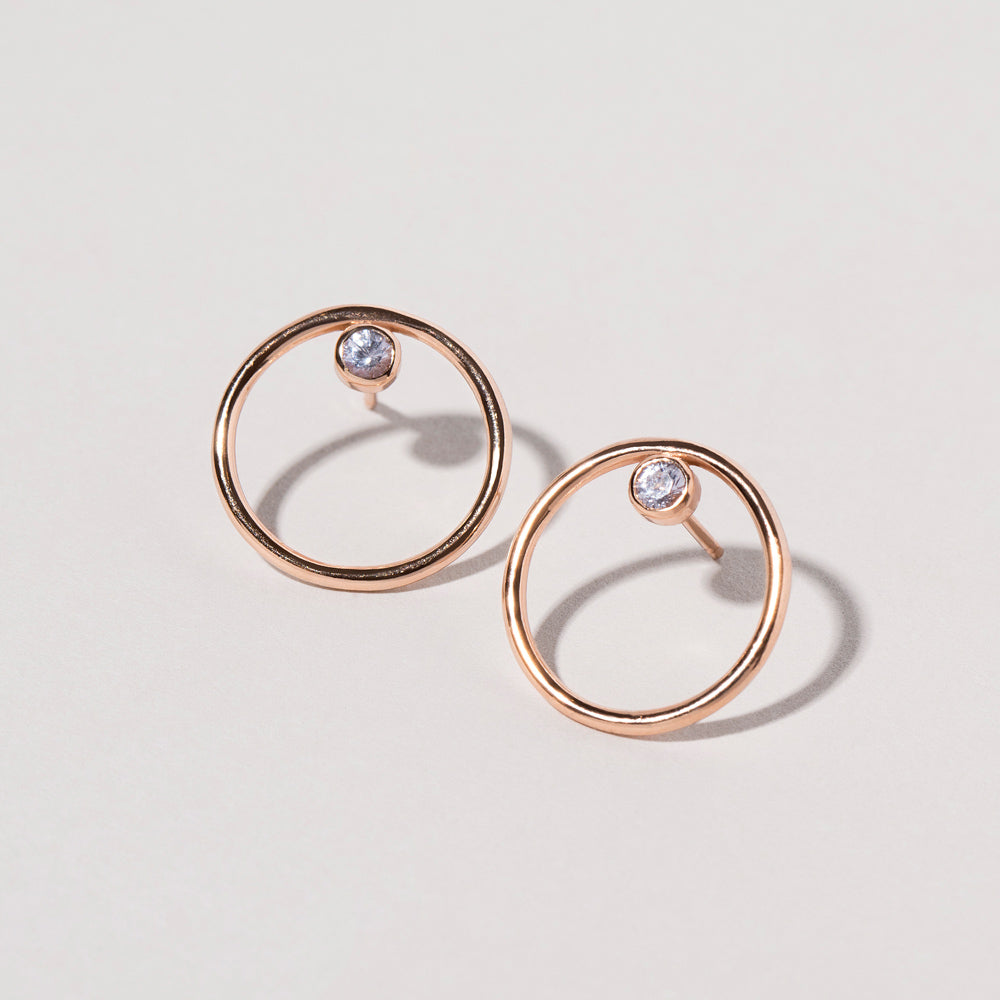 product_details::Closeup details of the Spinel Rose Gold Coil Stud Earrings on light color background.