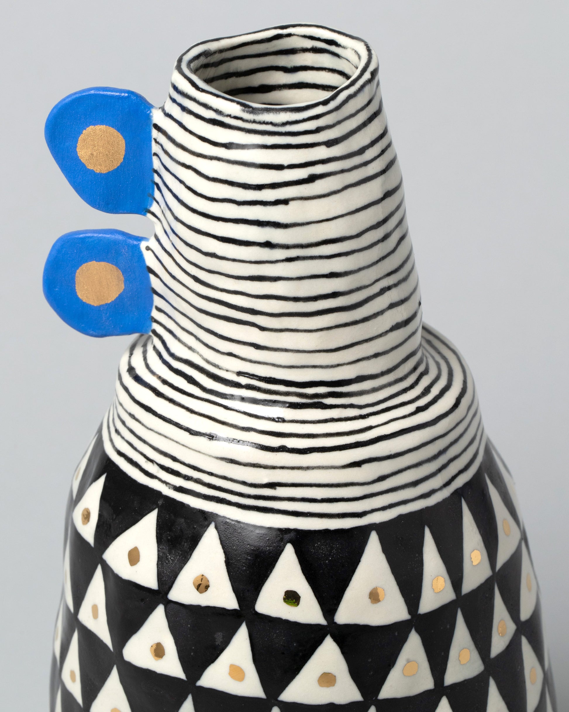 Closeup detail of the Suzanne Sullivan Tall Vase With Blue Handles on light color background.