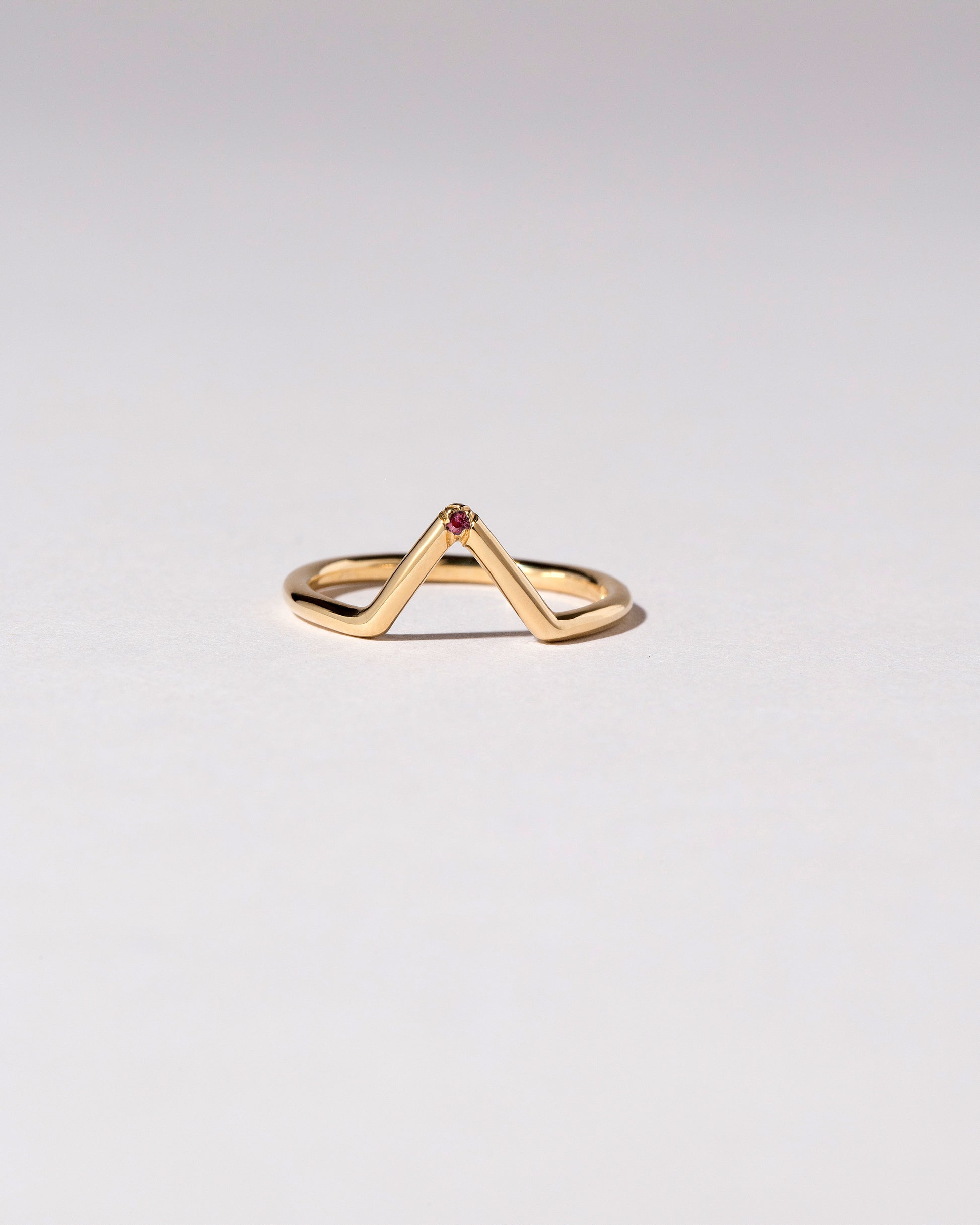 Gold Single Burnish-Set Red Ant Hill Garnet Triangle Band on light color background.