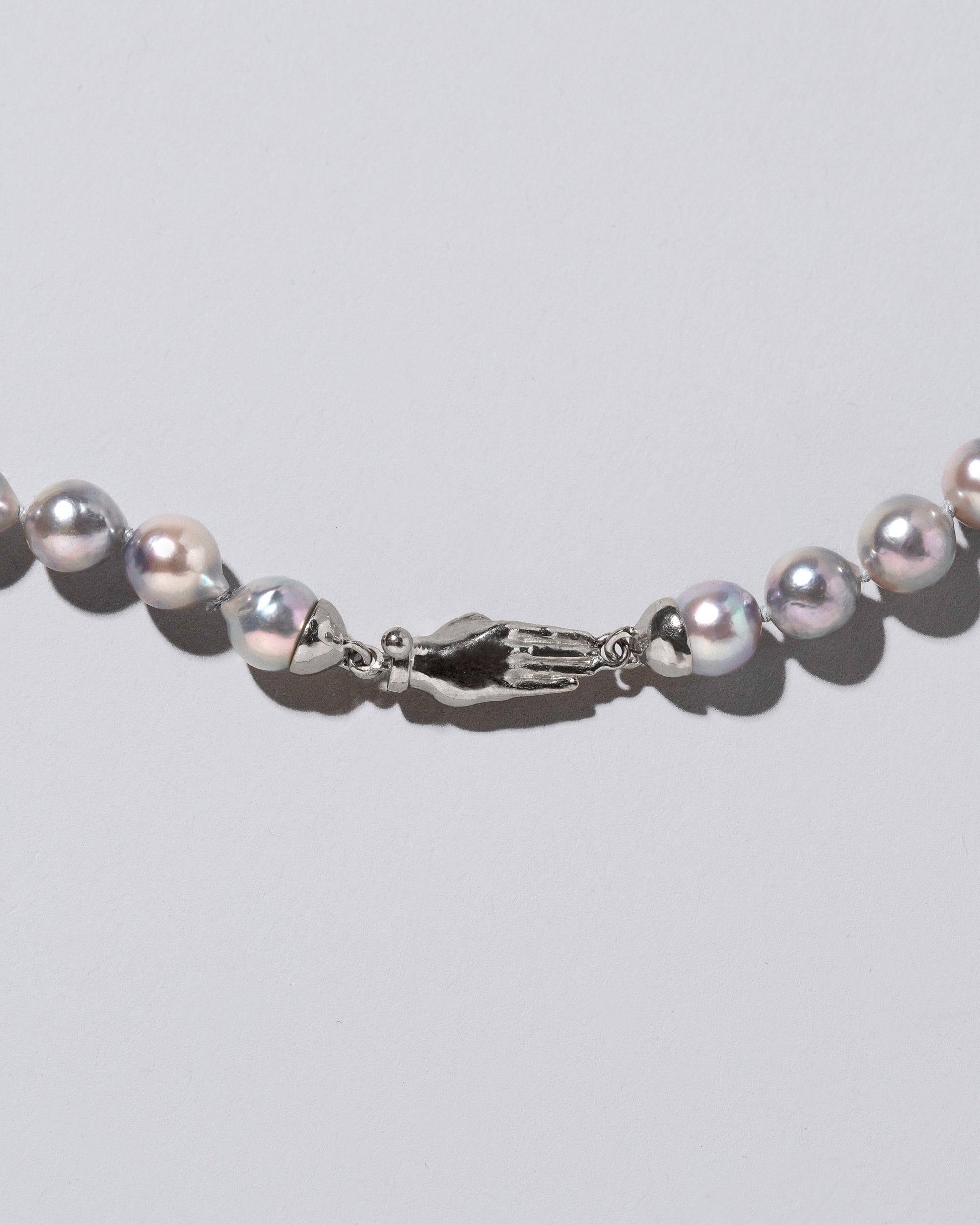Closeup detail of the Blue Pearl & White Gold Union Pearl Necklace on light color background.