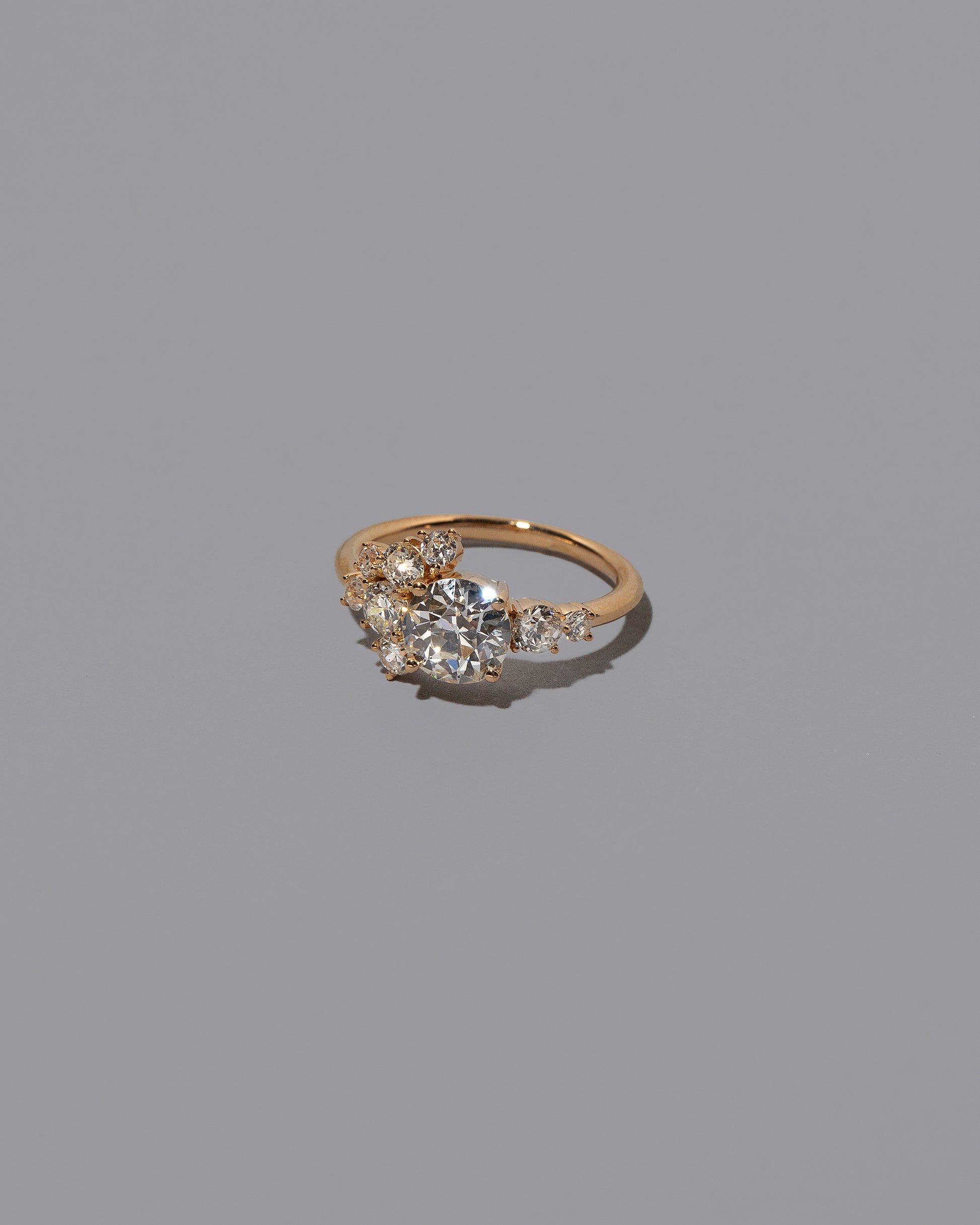 View from the side of the Grand White Diamond Vega Ring on grey color background.