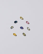 Photo of loose, colored gemstones on a light color background.