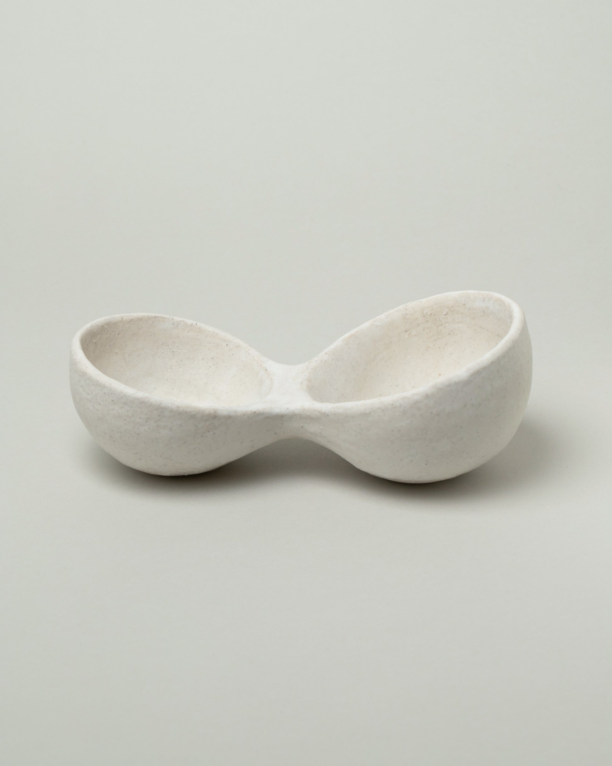 Closeup details of the Nur Ceramics White Nabra Double Bowl on light color background.