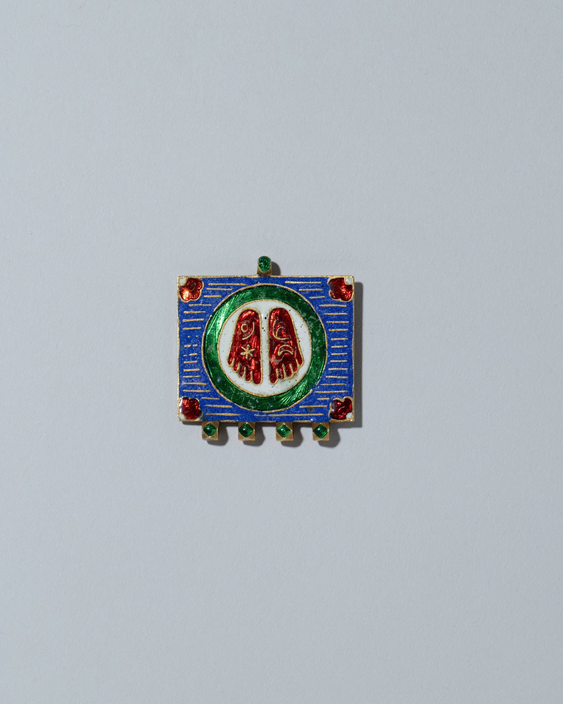 View from the back of the Antique Enamel Symbol Pendant on light color background.