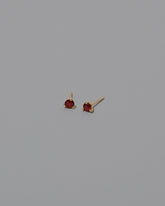 Magenta Ruby Martini Stud Earrings on light color background.