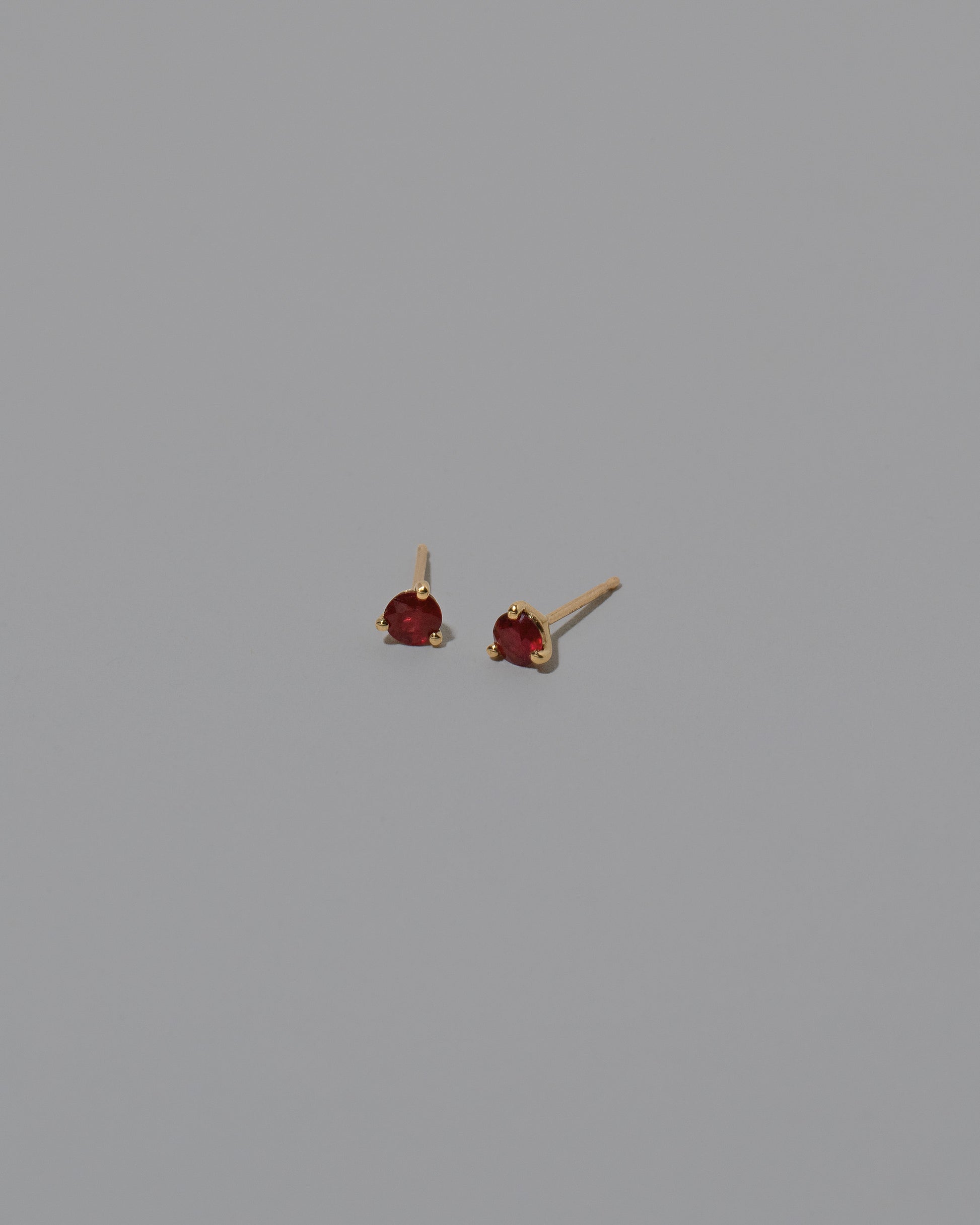 Magenta Ruby Martini Stud Earrings on light color background.