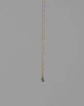 Turquoise Cabochon Birthstone Level Necklace on light color background.