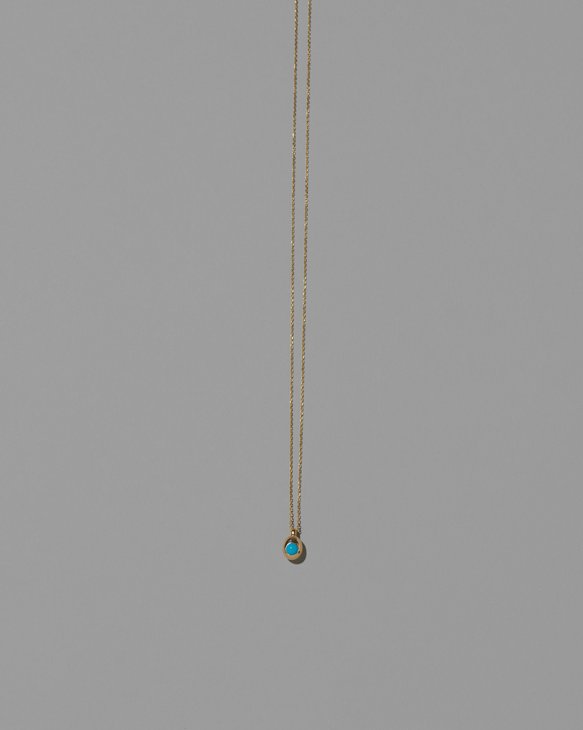 Turquoise Cabochon Birthstone Level Necklace on light color background.