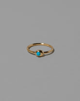 Turquoise Cabochon Birthstone Level Ring on light color background.