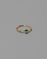 View from the side of the Turquoise Cabochon Birthstone Level Ring on light color background.