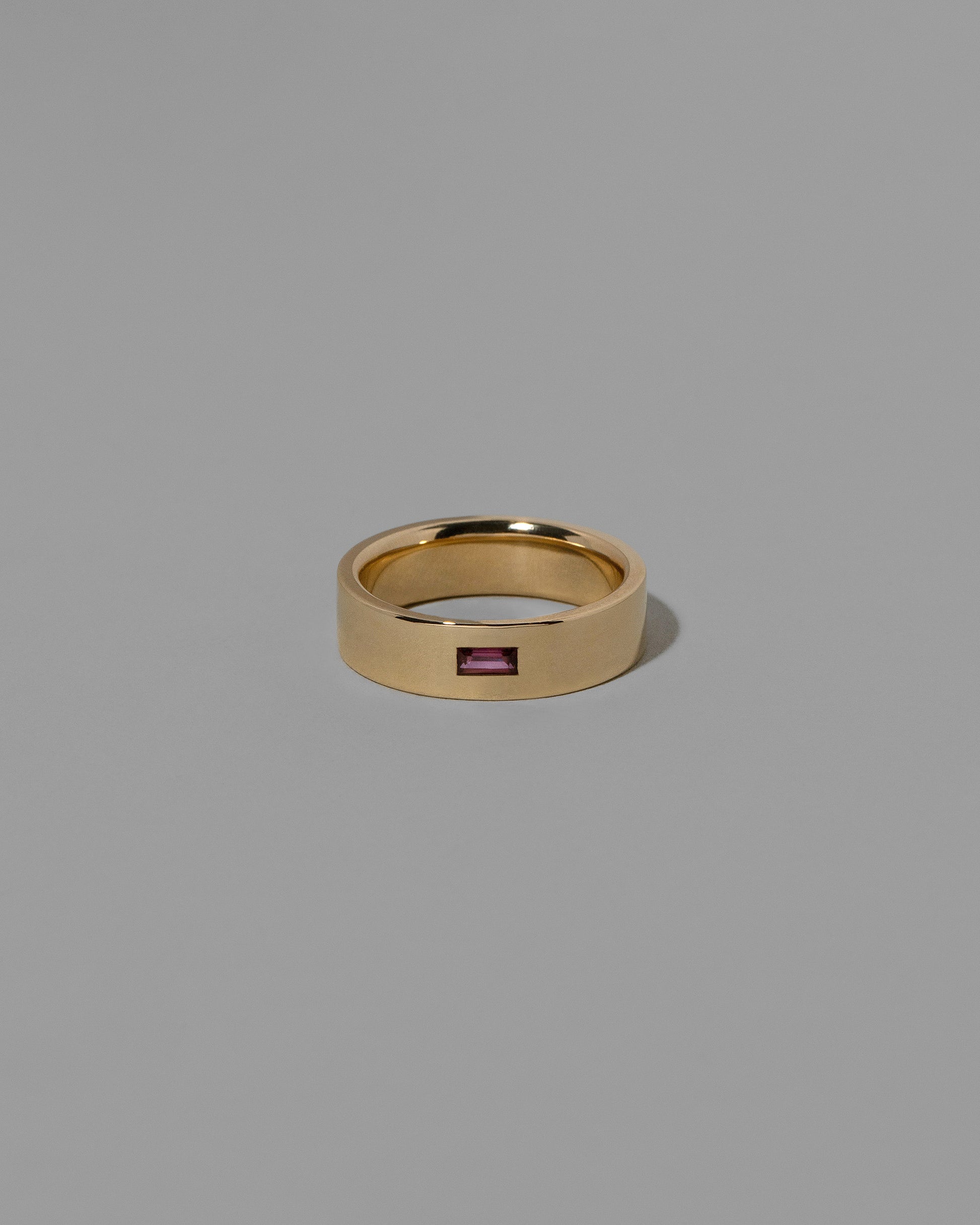 Gold Anthill Red Garnet East West 6mm Baguette-Set Piet Band on light color background.