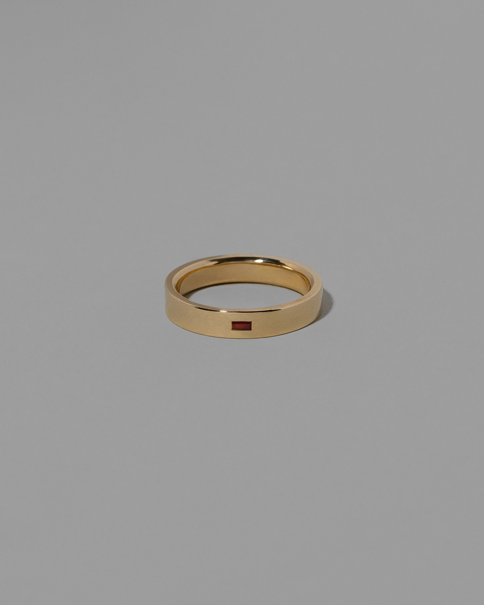 Gold Ruby East West 4mm Baguette-Set Piet Band on light color background.