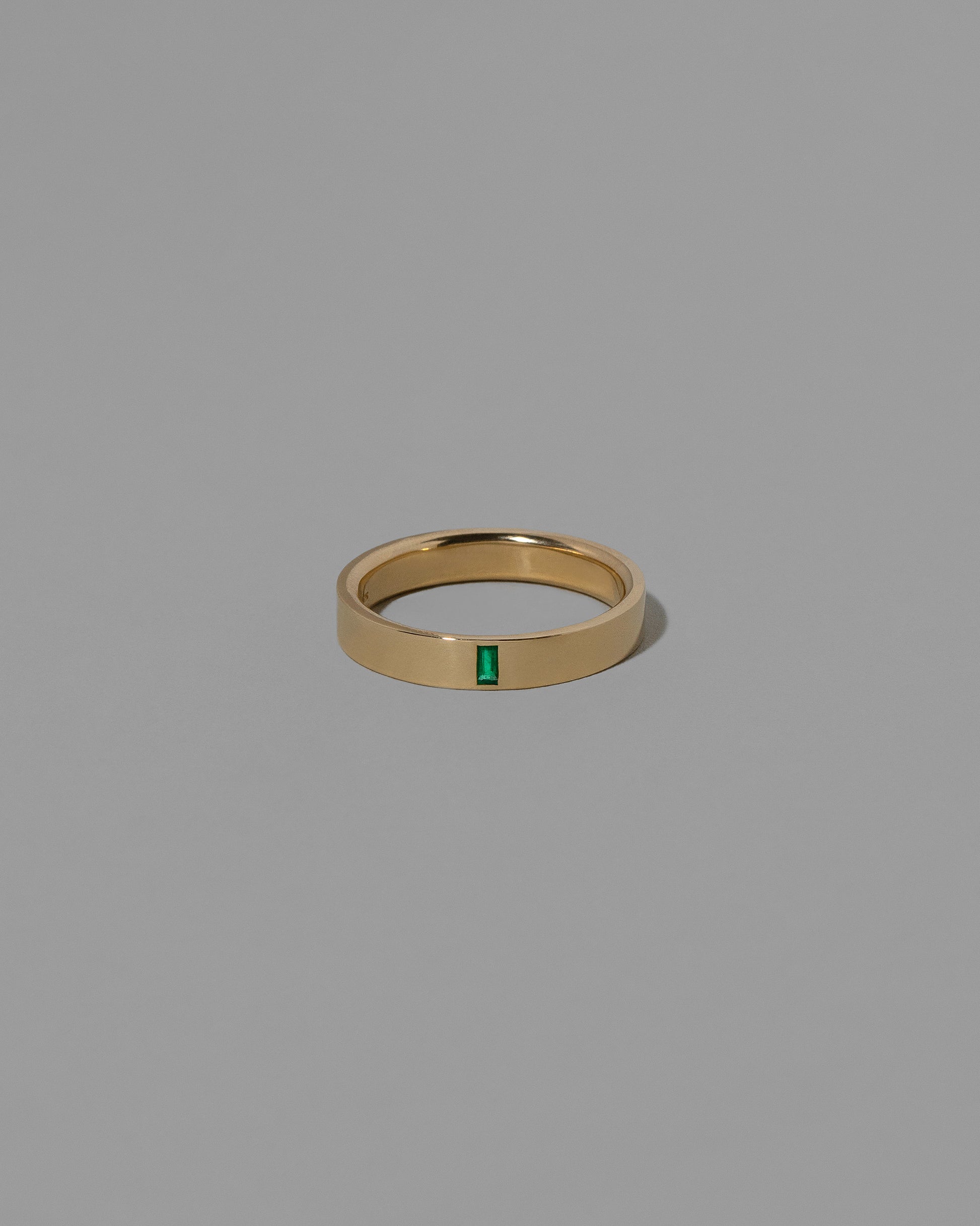 Gold Emerald North South 4mm Baguette-Set Piet Band on light color background.