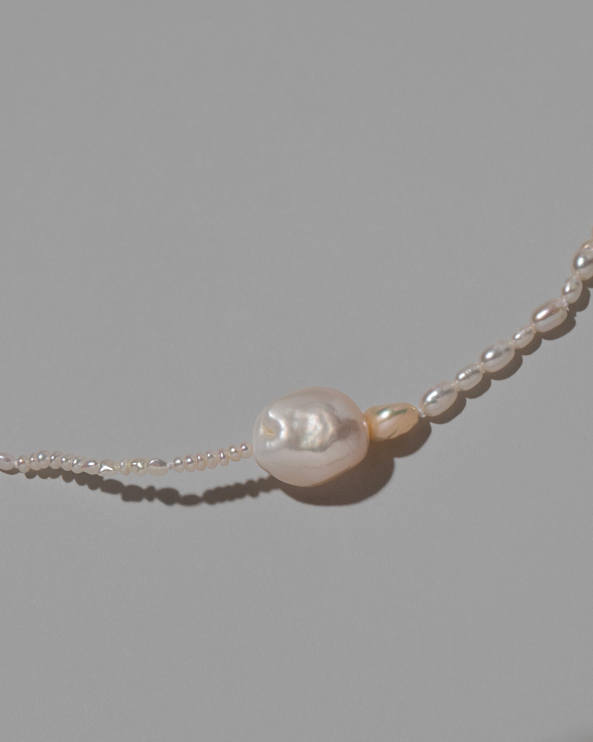 Closeup details of the Pontus Pearl Necklace on light color background.