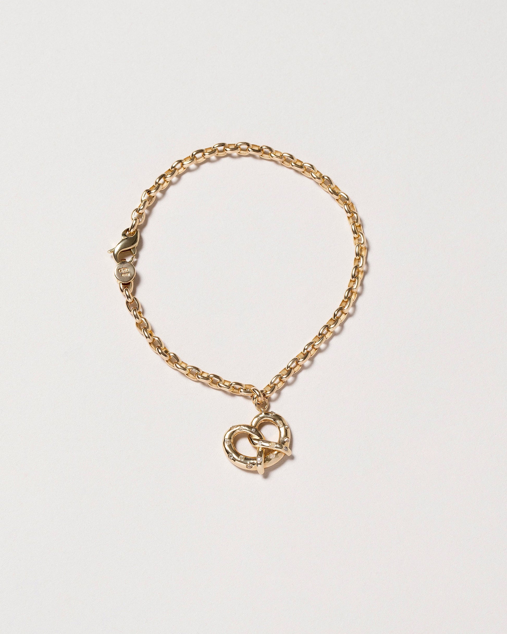 Salted Pretzel Charm and Short Loop Chain Bracelet on light color background.