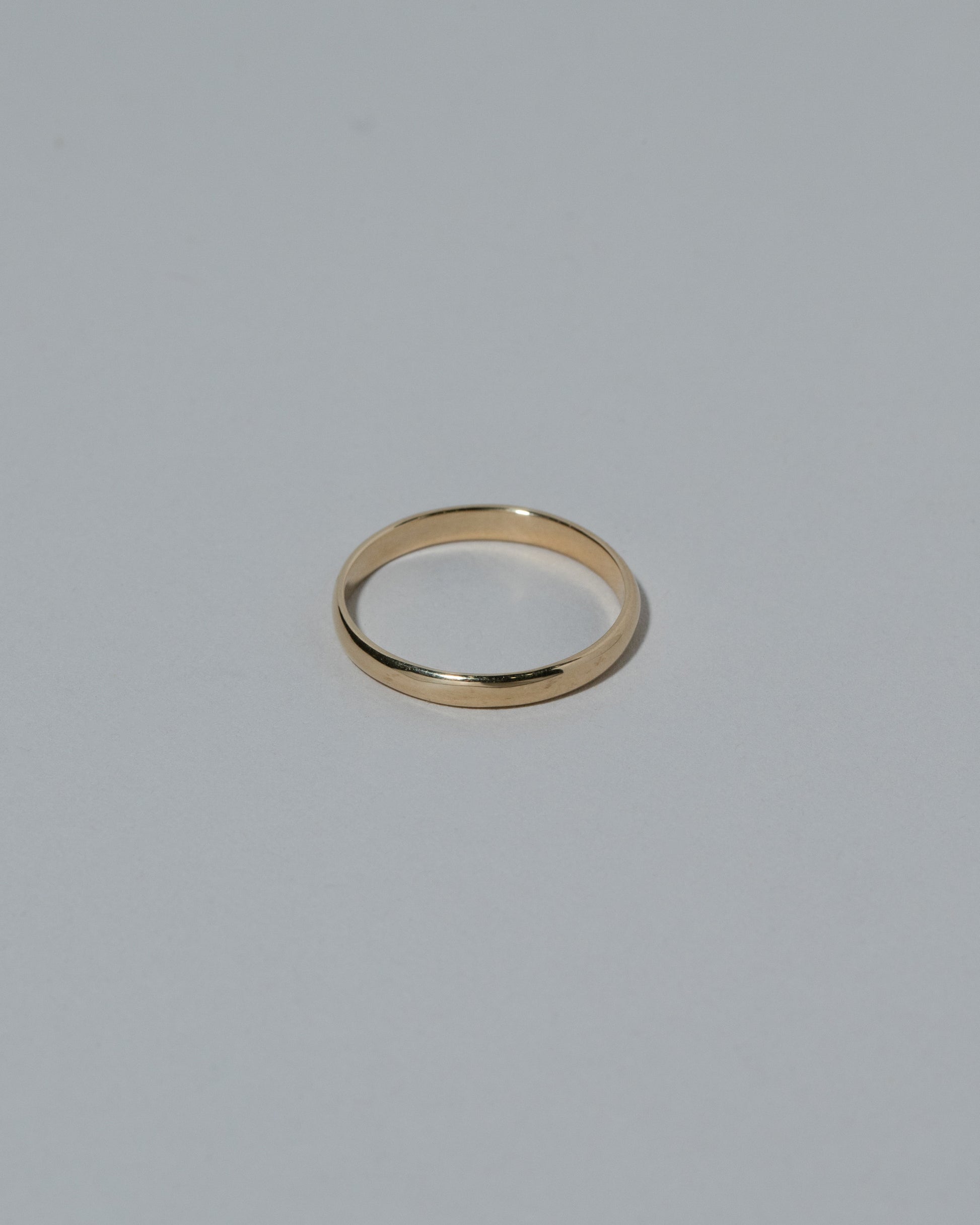 Samples & Imperfects 2.5mm 14k Yellow Gold Half Round Band on light color background.