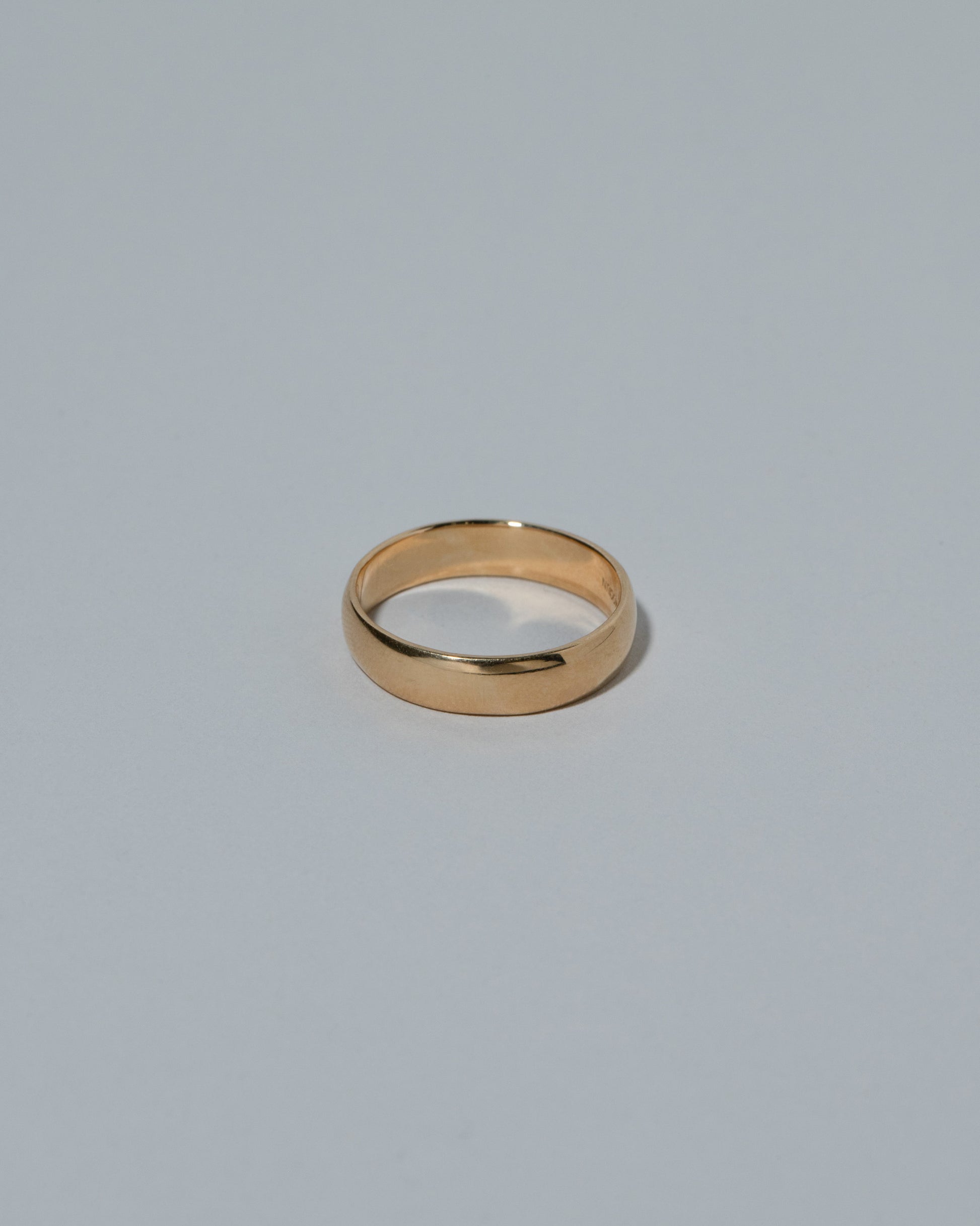 Samples & Imperfects 5.2mm Yellow Gold Half Round Band on light color background.