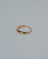 View from the side of the Samples & Imperfects 5mm 18k Yellow Gold Venus Band on light color background.