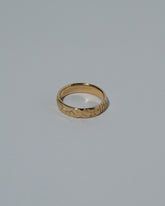 View from the side of the Samples & Imperfects 14k Yellow Gold Tahiti Band on light color background.