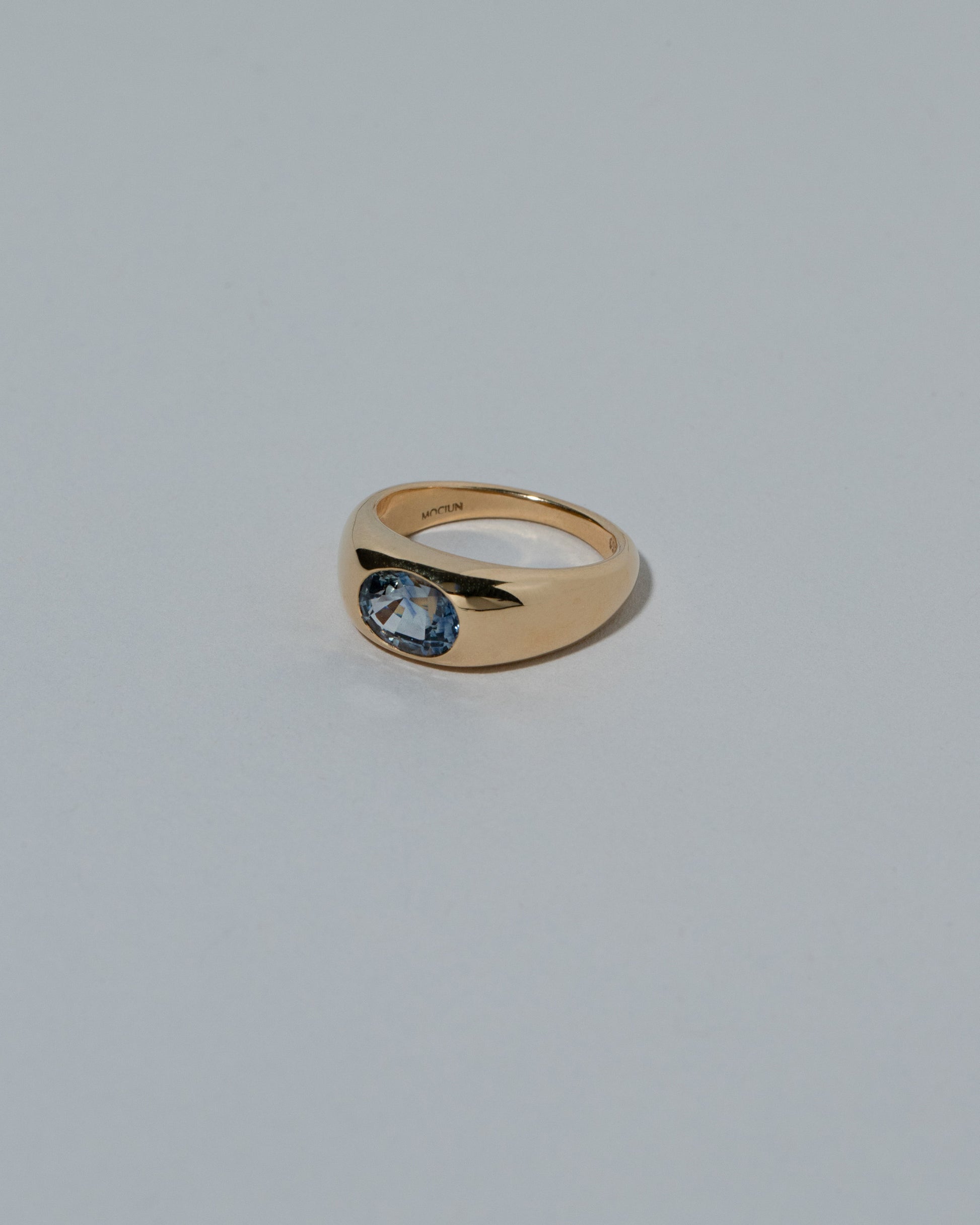 View from the side of the Samples & Imperfects Bicolor Blue Sapphire Jupiter Ring on light color background.