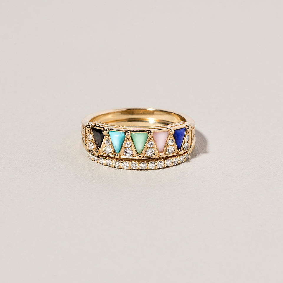 product_details::Gold Mega Five Triangle Ring and Gold Notched Band on light color background.