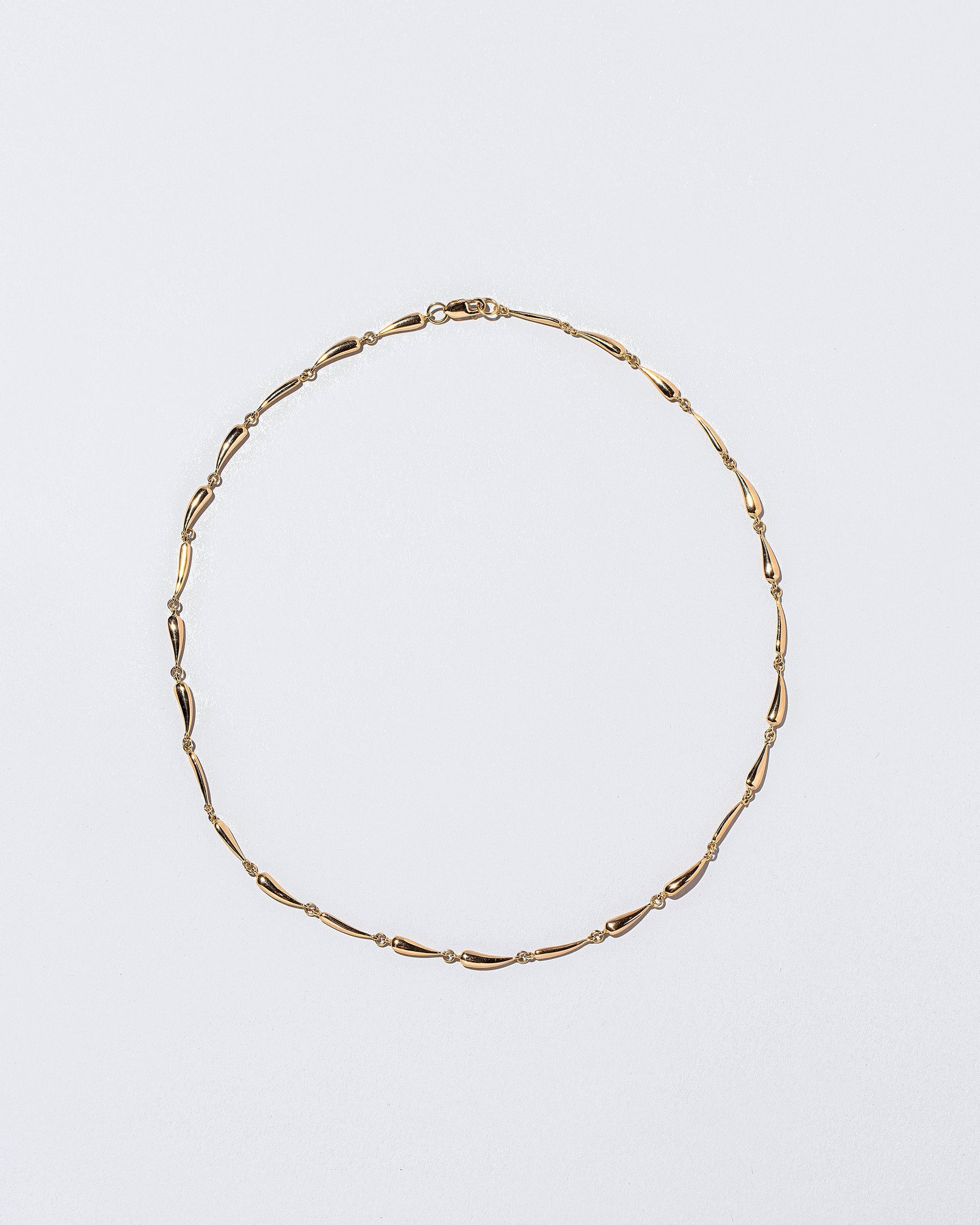 Gold Accumulation Necklace on light color background.