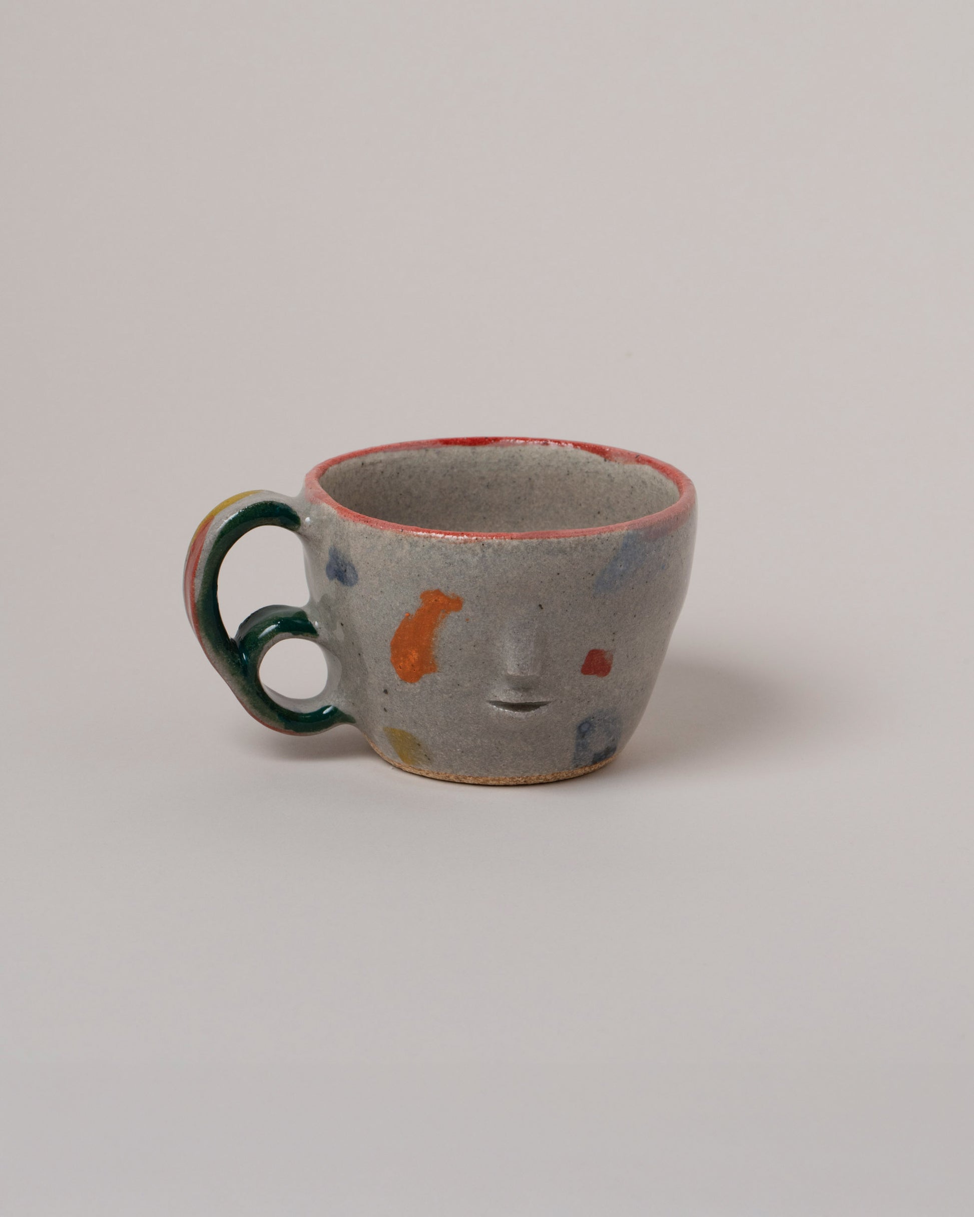 Rami Kim Orange Dream Face Mug With Double Loop Handle on light color background.