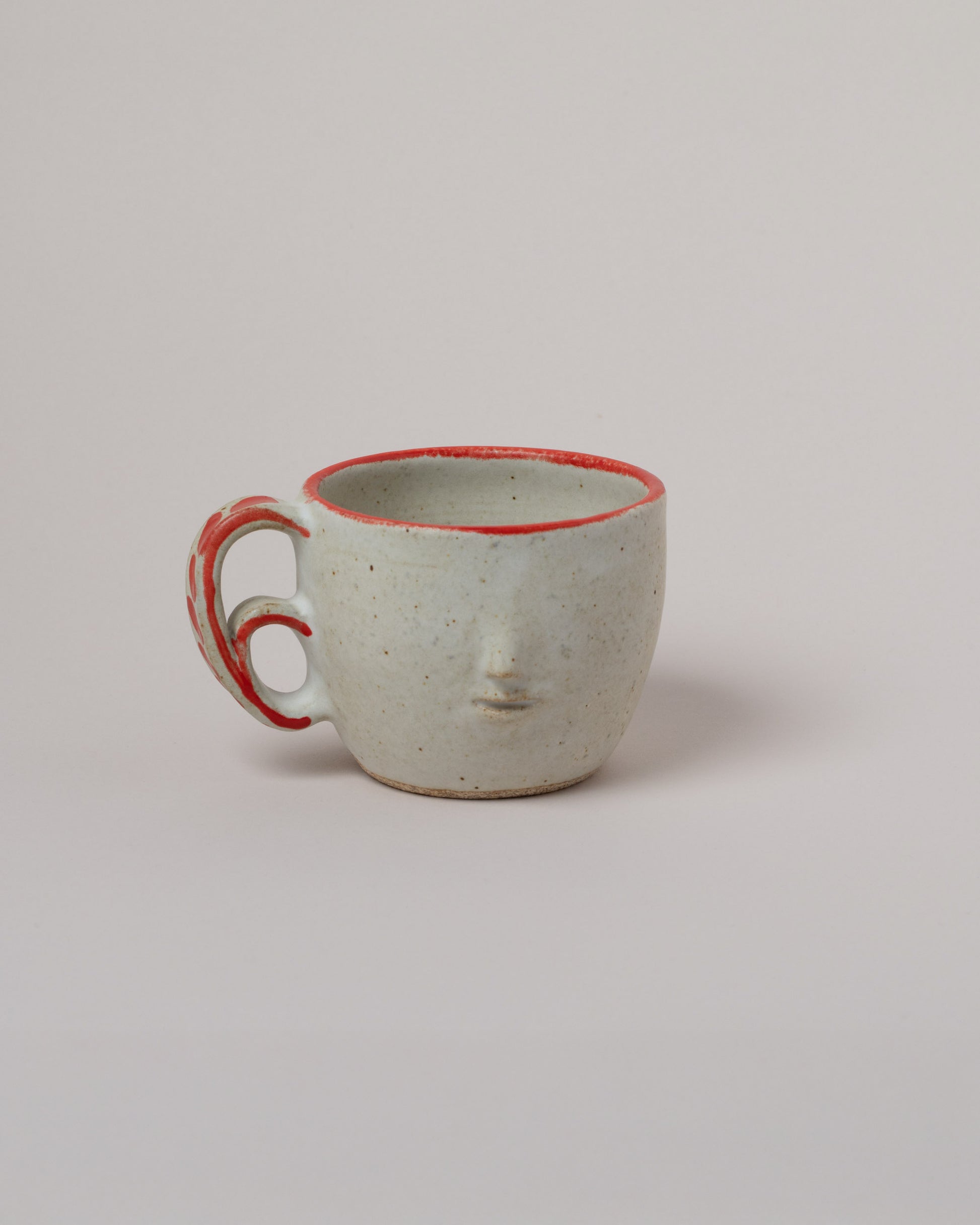 Rami Kim Red Swipe Accent Face Mug With Double Loop Handle on light color background.