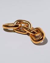 View from the side of the Carl Auböck Brass Chain Paperweight on light color background.