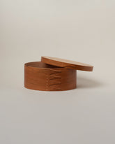 Detail view of the Rikke Falkow 11" Cherry Wood Oval Box on light color background.