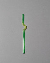 Misha Kahn Yellow and Green Suck It Up Glass Cocktail Straw on light color background.