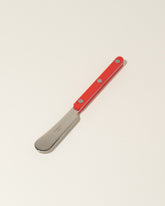 Sabre Paris Red Butter Spreader on light color background.