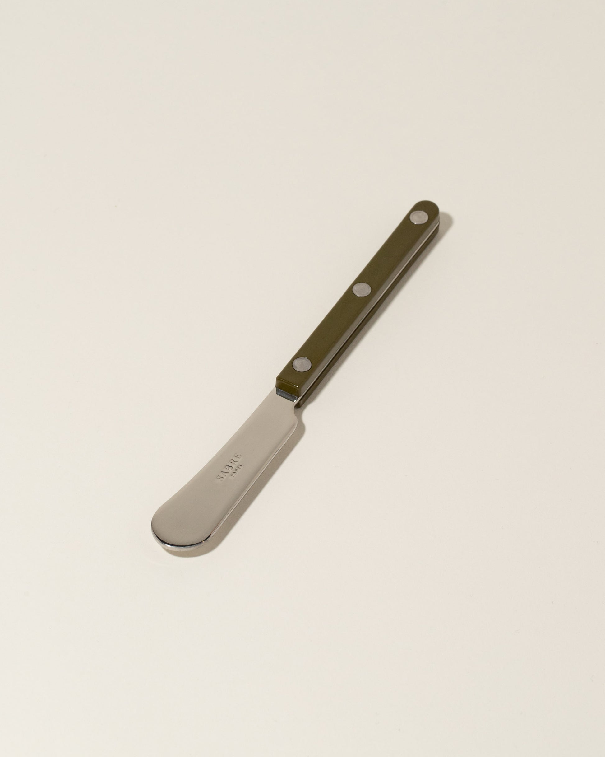 Sabre Paris Green Fern Butter Spreader on light color background.